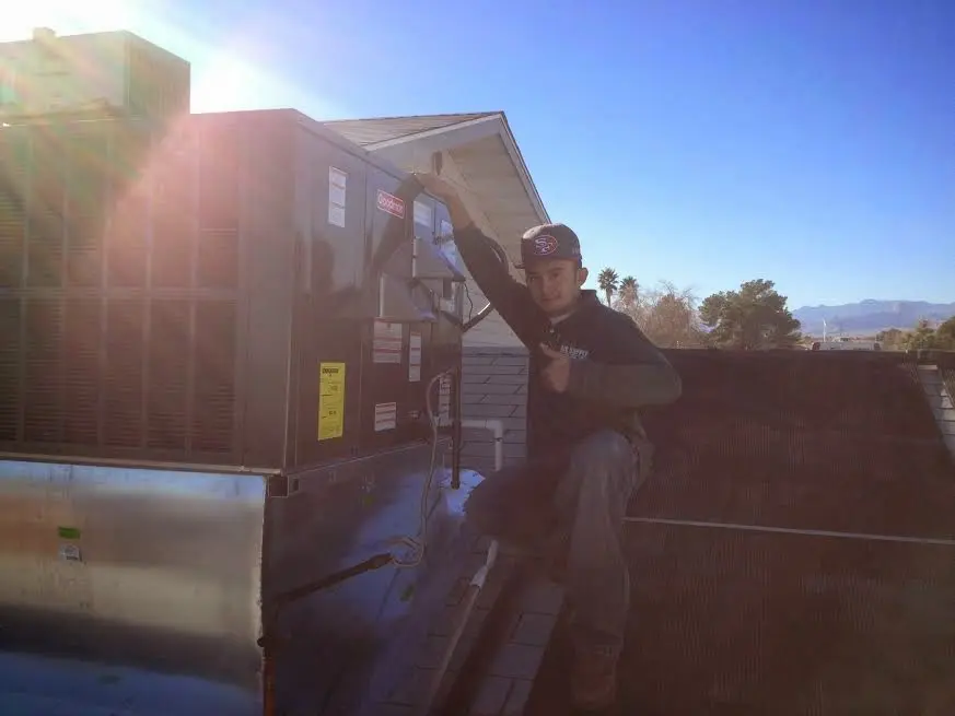 HVAC technician performing Boiler Repair on a rooftop unit in Griffith